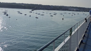 A marina with multiple boats anchored in calm waters, a bridge with a railing, and a distant shoreline with buildings. - 2bed-cabin Sleeps 4, Wifi, Free Parking, Sea Views (Bembridge)