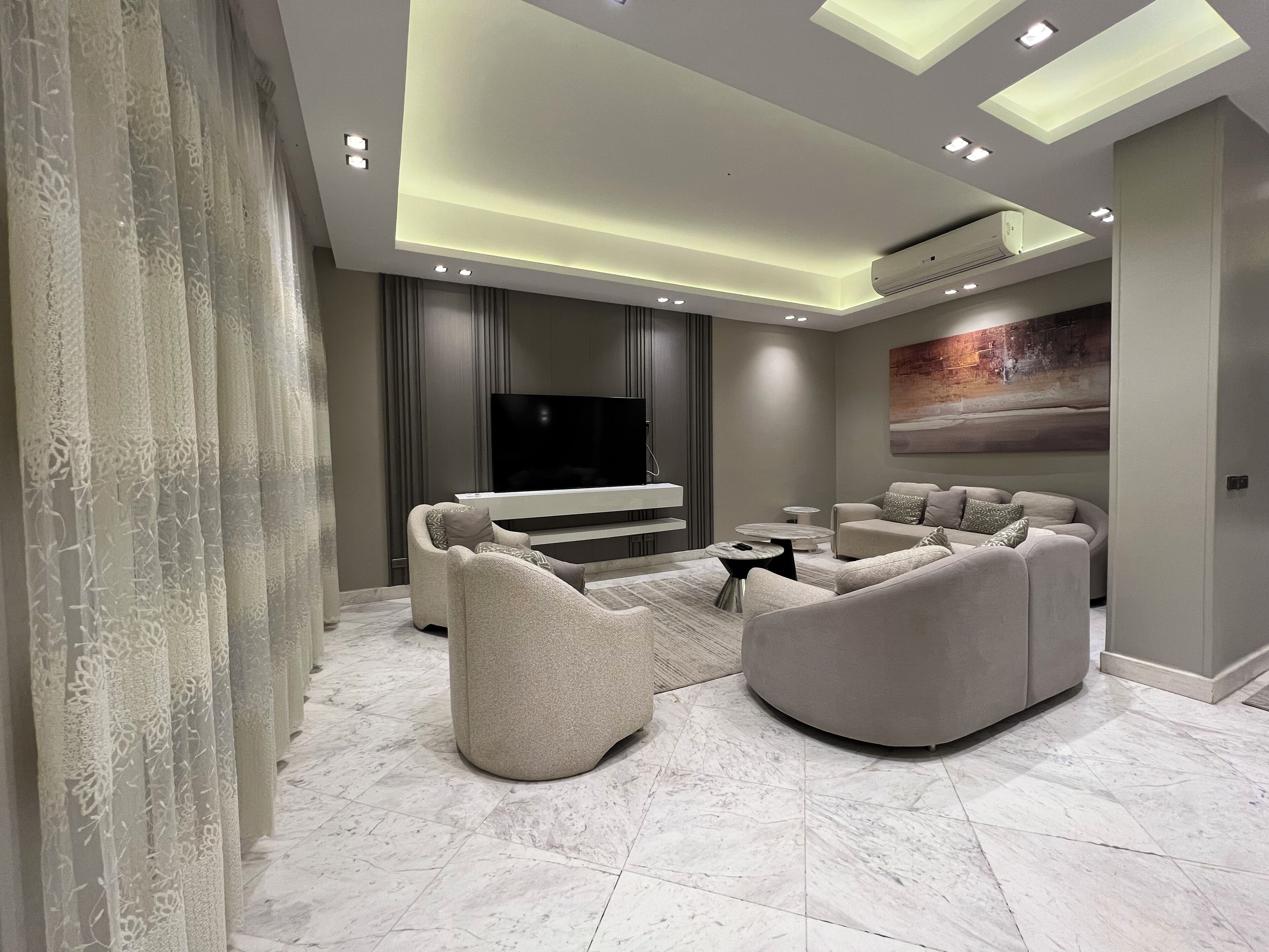 Un salon moderne avec un téléviseur à écran plat, des canapés et une table basse.