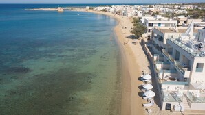 A coastal hotel with a beach view, multiple balconies, and outdoor seating areas. - scirocco boutique eco hotel (Torre Pali)