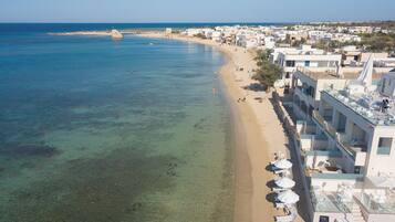 Sulla spiaggia, sabbia bianca, lettini da mare, ombrelloni
