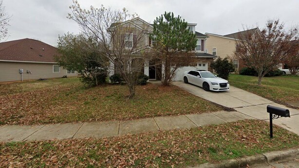 A residential area with houses, a driveway, and a mailbox. - Cozy 1-bedroom condo in peaceful Garner with AC (Garner)