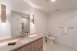 A modern bathroom with a large mirror, a sink, and a toilet. - Saiya  1120 (Phoenix)