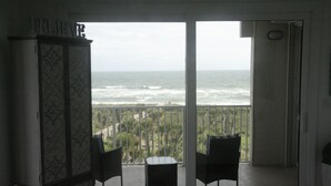 A room with a view of the ocean, a cabinet, and two chairs. - 
Amazing waterfront condo with an amazing view of the beach, an amazing sunrise (Palm Coast)