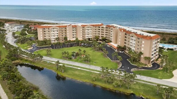 A beachfront hotel with multiple buildings, a parking area, and a body of water. - 
Amazing waterfront condo with an amazing view of the beach, an amazing sunrise (Palm Coast)