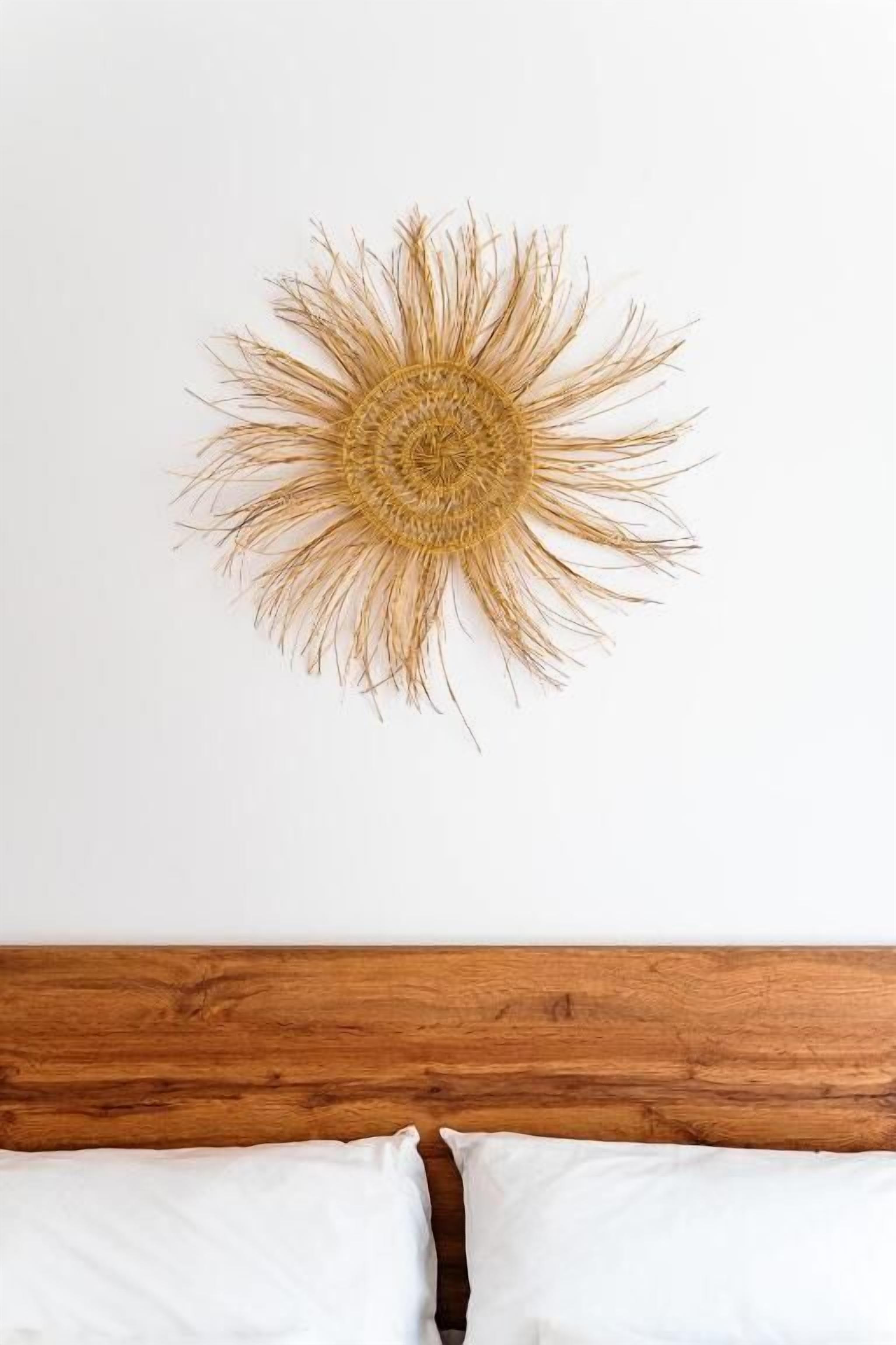 A room with a wooden headboard and a circular wall decoration.
