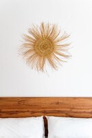 Una habitación con cabecera de madera y un adorno circular en la pared.