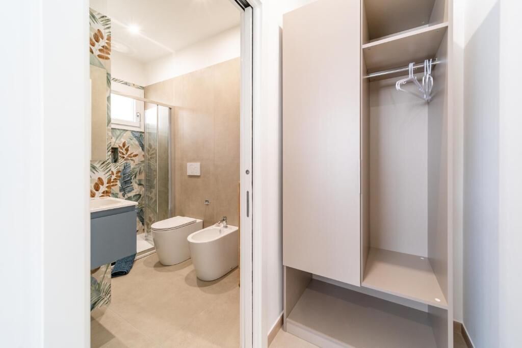 A modern bathroom with a shower, toilet, and bidet.