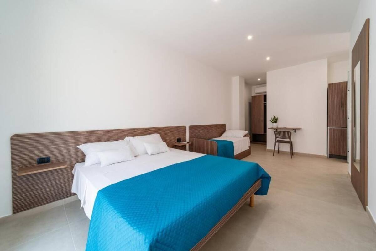 A modern hotel room with a large bed, a desk, and a chair.