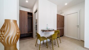 A modern interior with a dining area featuring two chairs and a table, a wooden cabinet, and a white door.