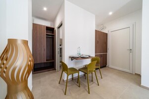 Un intérieur moderne avec un coin repas comprenant deux chaises et une table, un meuble en bois et une porte blanche.