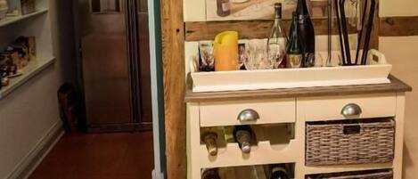 Una cocina con una estantería para vinos, un refrigerador y estructura de vigas de madera.