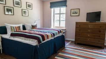 Un dormitorio con cama, cómoda y ventana.