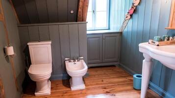 A bathroom with a toilet, bidet, and sink.