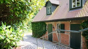 A traditional house with a brick facade, green shutters, and a tiled roof. - Alcor Exclusive Friedrichsruh (Aumuehle)
