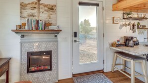 A cozy room with a fireplace, books on a shelf, a coffee bar, and a view of the outdoors. - Incredible Views at Tiny Heaven In Cottonwood (Cottonwood)