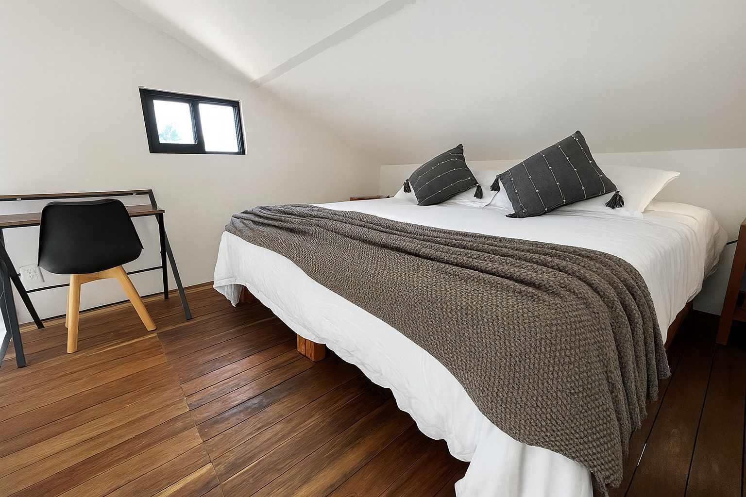 Ein Schlafzimmer mit einem Bett, einem Schreibtisch und einem Stuhl.