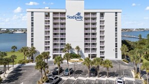 Ein mehrstöckiges Hotel mit einem markanten 'SeaPay Riverside' Schild, mit Balkonen und einem Parkplatz mit mehreren Fahrzeugen.