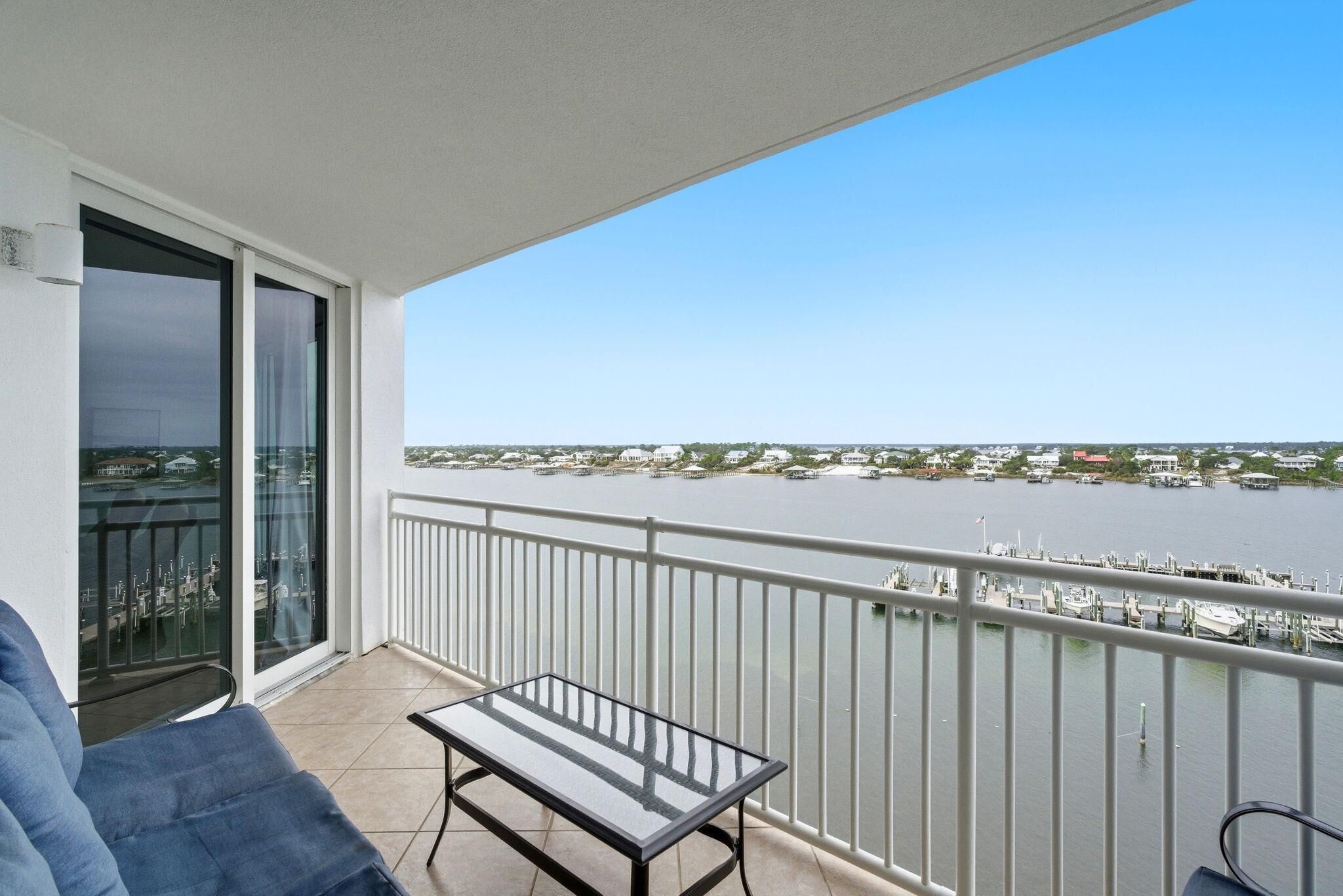 A balcony with a glass door, a table, and a chair.