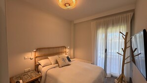Un dormitorio con cama, mesita de noche, lámpara y una estructura decorativa de madera.