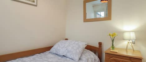 Un dormitorio con cama, cómoda, espejo y un cuadro en la pared.