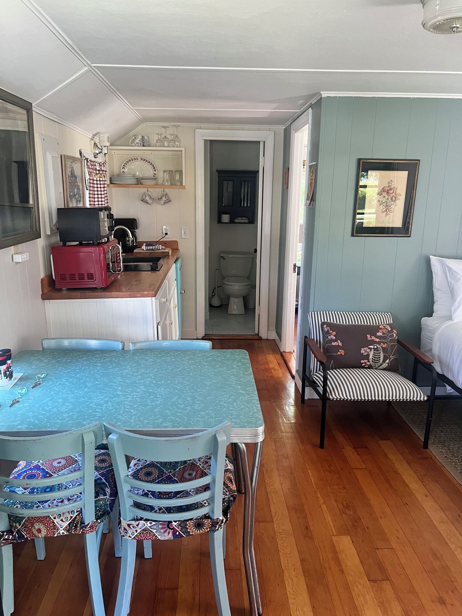 A compact living space with a dining area, kitchenette, and a small bathroom.