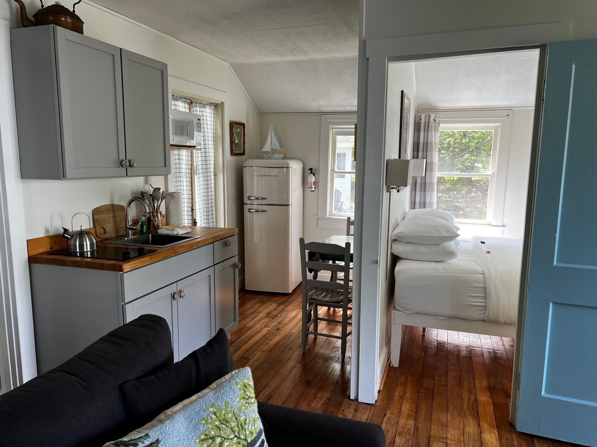 A compact living space with a kitchenette, a dining area, and a bedroom.