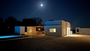 Un bâtiment moderne, de plain-pied, doté d’une piscine, d  ’un espace patio et d’un petit jardin.