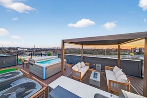 Terraza en la azotea con jacuzzi, mobiliario exterior y vistas a la ciudad.