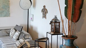 A cozy bedroom with a bed, bedside table, lamp, and a large vase with plants. - New! Tikanot'la haut Exceptional view of Grande Anse beach (Deshaies)