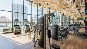 A gym with various exercise equipment, large windows, and a wooden ceiling. - Saiya  920 (Phoenix)