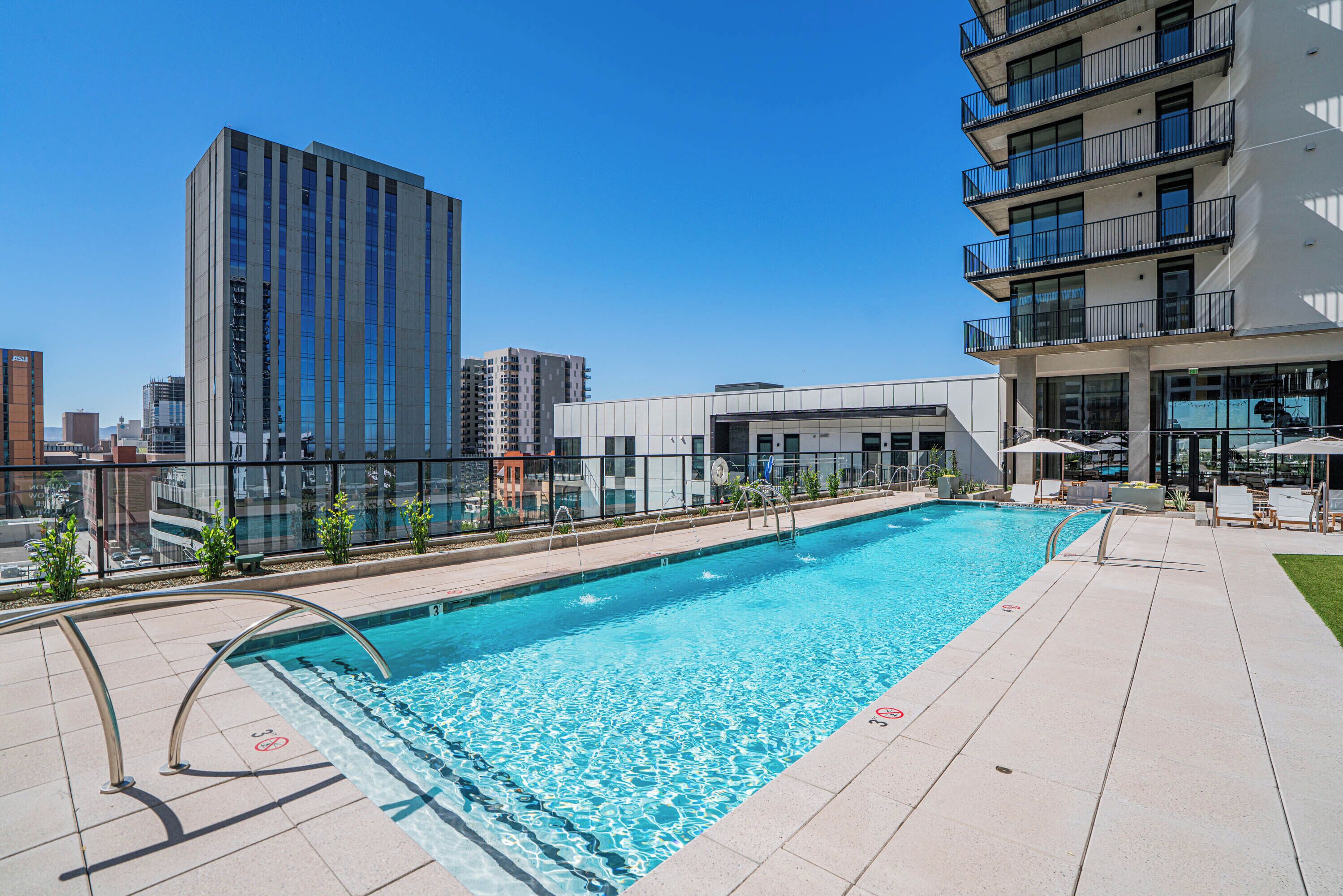 A rooftop pool with a clear view of the city skyline, surrounded by modern buildings.