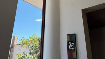A room with a ceiling-mounted smoke detector, a security camera, and a door frame.