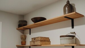 Ein Waschraum mit Waschmaschine, Trockner und Regalen mit Körben und Behältern.
