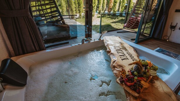 A bathtub with a wooden tray of fruits and a towel. - Green Yazıcı Villas (Ardesen)