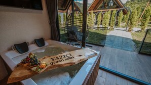 A wooden table with a message, a bathtub, and a view of a wooden cabin. - Green Yazıcı Villas (Ardesen)