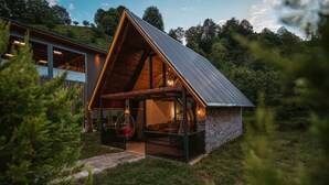 A modern house with a sloped roof, a glass entrance, and a cozy interior with seating. - Green Yazıcı Villas (Ardesen)