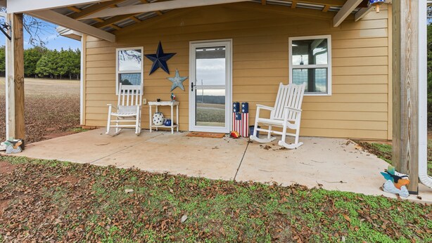 A covered porch with two rocking chairs, a star decoration, and American flags.
