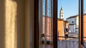 Une vue à travers une fenêtre, avec un bâtiment et une église en arrière-plan.