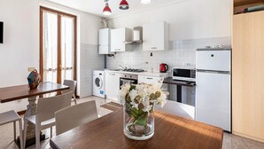Eine kleine Küche mit Waschmaschine, Mikrowelle und Kühlschrank.