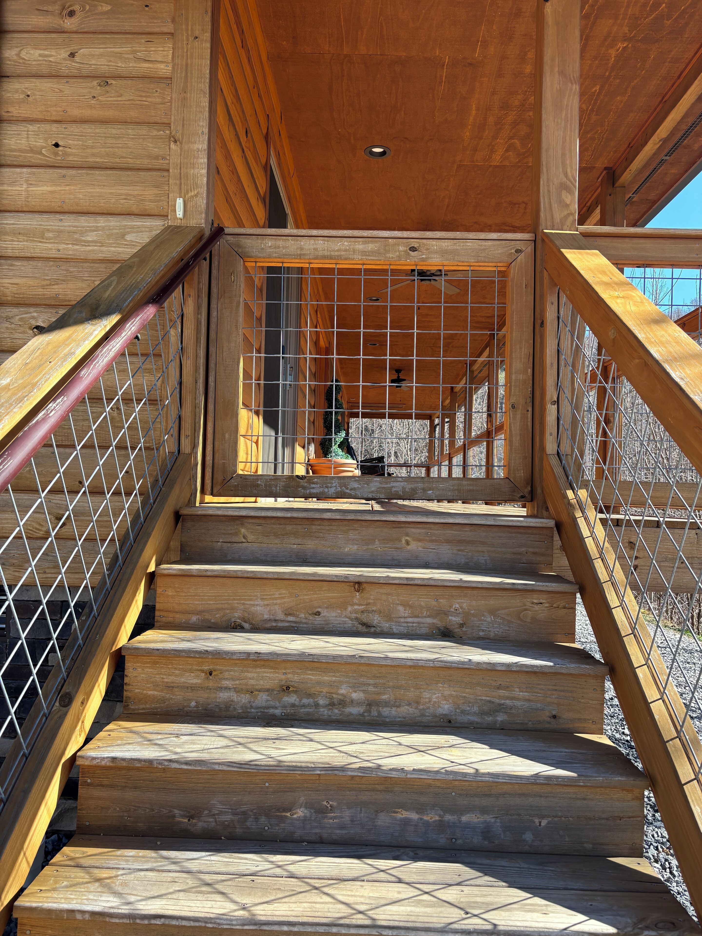 A wooden staircase with metal railings leading to an upper level.