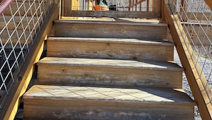 Una escalera de madera con barandillas de metal que conduce a un nivel superior.