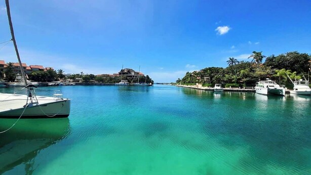 Un puerto deportivo con barcos amarrados, agua tranquila y cielo despejado.