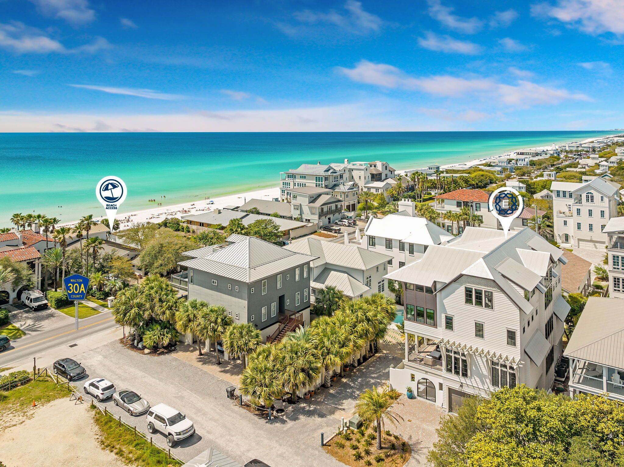 A coastal residential area with beachfront access, houses with balconies, and a clear view of the ocean.