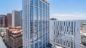 A modern high-rise building with a glass facade, surrounded by other high-rise buildings in an urban setting. - Kenect 916 (Phoenix)