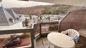 Un balcon donnant sur la ville, une chaise et une voiture gar ée à l’extérieur.