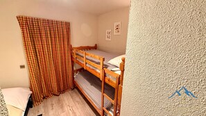 A small, cozy room with a bunk bed, a checkered curtain, and a few wall decorations. - L'Oise 209 Le Mo, t Dore 6pers (Mont-Dore)