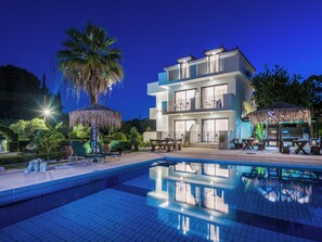 A modern hotel with a pool, outdoor seating, and a well-maintained garden. - Mon Repo Suites (Laganas)