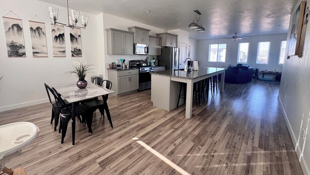 A spacious kitchen with modern appliances, a dining area with a marble table, and a large island with bar stools.