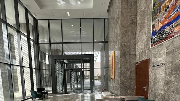 Eine großzügige Lobby mit modernem Design, ausgestattet mit einer breiten Sitzecke, Sofas, einem Couchtisch, einem Marmorboden und großen Fenstern für natürliches Licht.