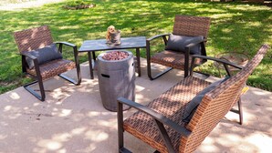 A patio with wicker furniture and a fire pit.